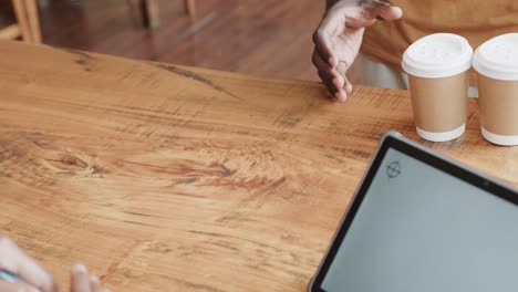 Detail-of-african-american-man-making-payment-with-smartwatch-at-coffee-shop,-slow-motion