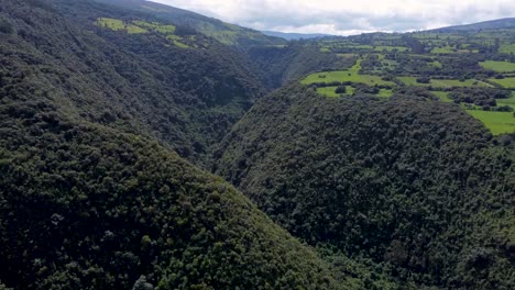 movimiento cinemático de drones sobre un cañón y un río cubiertos de plantas en puichig, volcán pasochoa, machachi, ecuador