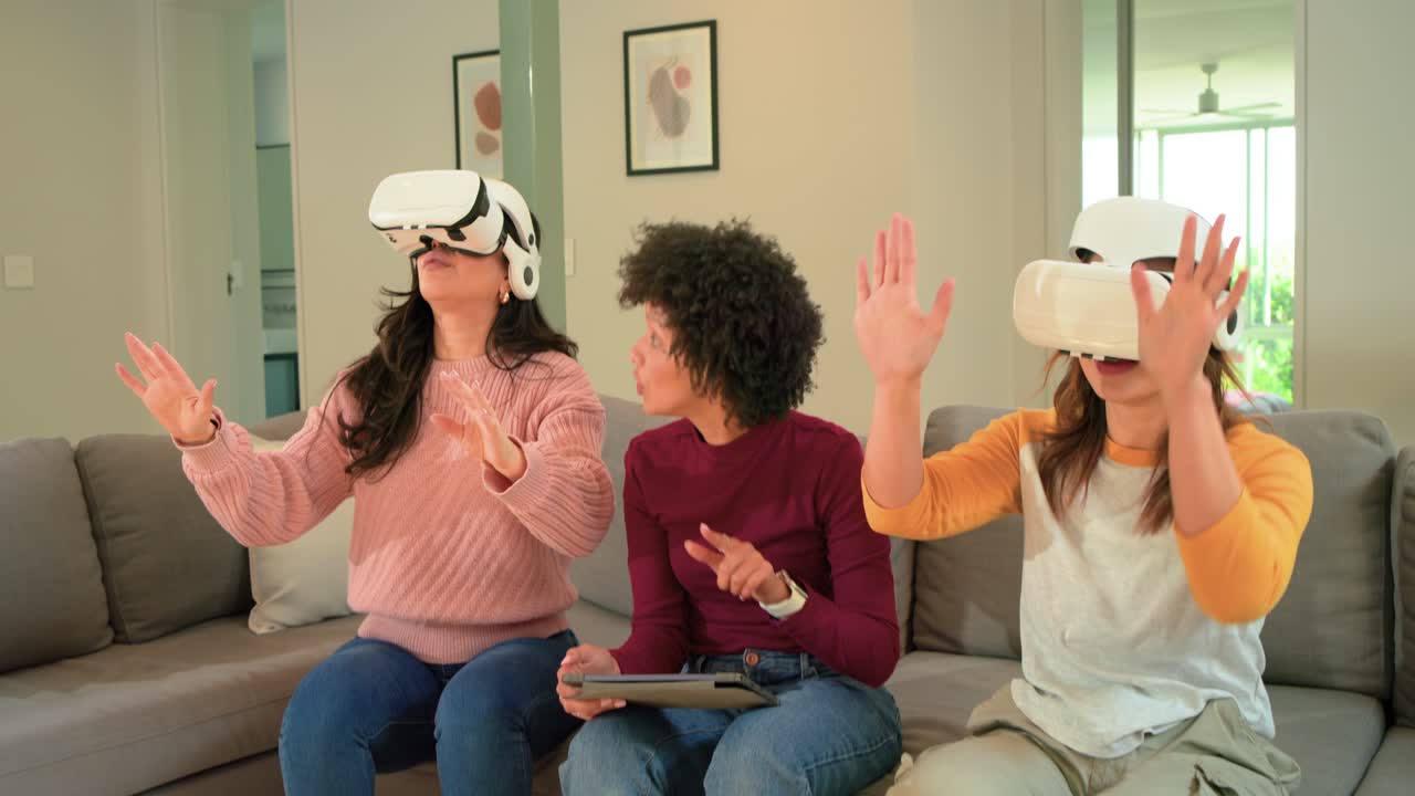 Diverse amiche che indossano visori VR, usano un tablet per avviare l'app e gesticolano in soggiorno