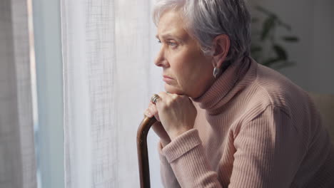 thinking, sad and senior woman with walking stick