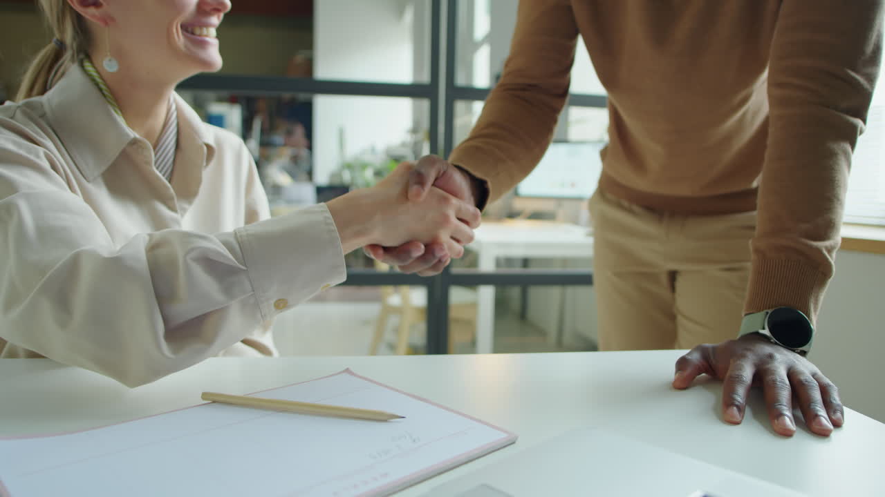 Businesswoman Shaking Hands with Colleague in Office
