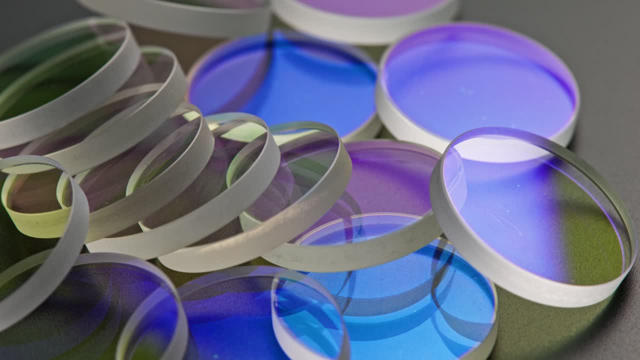 검은색 표면에 쌓인 평평한 둥근 유리 조각의 전체 프레임 루프 회전 배경