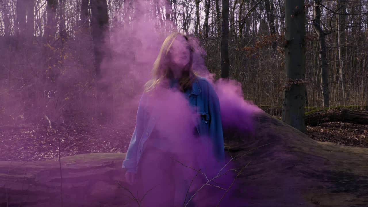 Girl leaning on a Tree out of which comes purple Smoke - Slowmotion