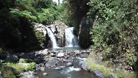 un dron disparó hacia una de las cascadas de alingaling en bali, indonesia, mientras se podía ver a los turistas caminando