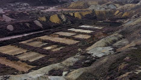 Parys-mountain-abandoned-historic-copper-mine-red-stone-mining-industry-landscape-aerial-view-zoom-in