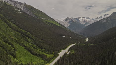 Rogers-Pass-Bc-Canada-Drone-V4-Aéreo-Sobrevolando-La-Autopista-Transcanadiense-Capturando-Un-Exuberante-Valle-Boscoso,-Las-Cadenas-Montañosas-De-Selkirk-Y-El-Pico-Youngs-En-El-Fondo---Filmado-Con-Mavic-3-Pro-Cine---Julio-De-2023