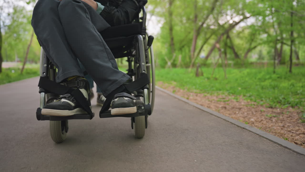 Footwear Resting On Wheelchair Path, Closeup Of Shoes And Wheelchair Trail Outside, Footwear And Mobility Devices Captured On Outdoor Green Trail Showing Shoes And Wheelchair In Detail