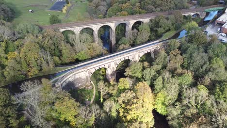 backwards reveal into clockwise orbit aerial drone clip of marple aqueduct and viaduct in the united kingdom