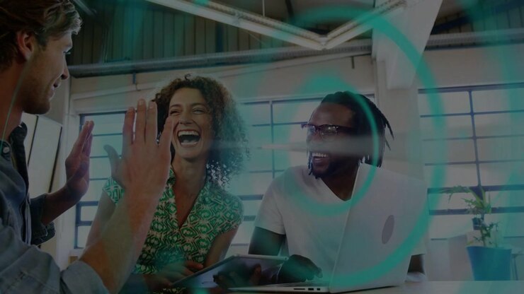 Business team leaning at laptop, left pointing, starting teal overlay, cheering, reviewing tablet