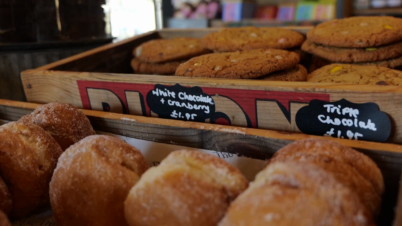 Órbita izquierda alrededor de galletas caseras y donas azucaradas en una tienda de granja en toma abierta durante el día.