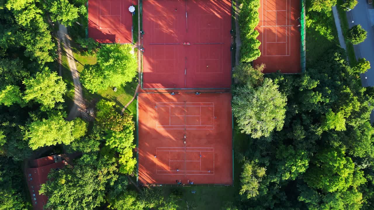 Diversi campi da tennis immersi in una fitta foresta, che offrono una fuga tranquilla nel cuore della città di Berlino. Splendida vista aerea verticale con drone.