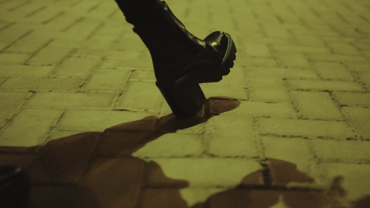 piernas femeninas caminando de noche en zapatos de tacón alto en la calle de la ciudad.