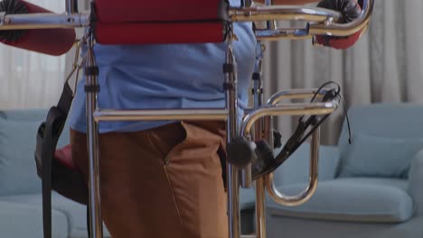 cerca de una mano tocando el hombro del paciente llorando asiático alentando a caminar con un andador durante una terapia física en casa