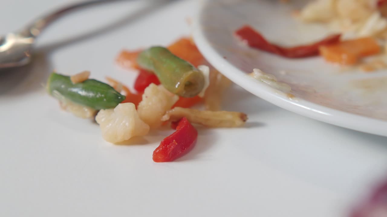 Leftover chopped vegetables on a white plate and table