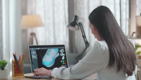 mujer diseñando zapatos en una computadora portátil