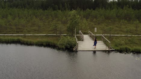 Zooming-on-girl-standing-on-the-edge-of-footbridge-and-walking