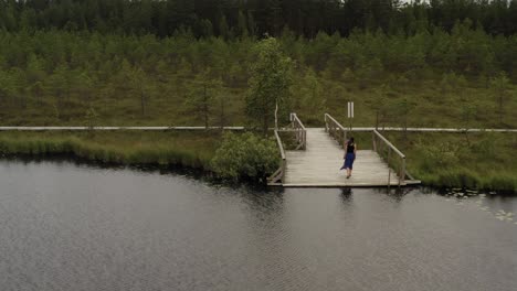 zooming on girl standing on the edge of footbridge and walking