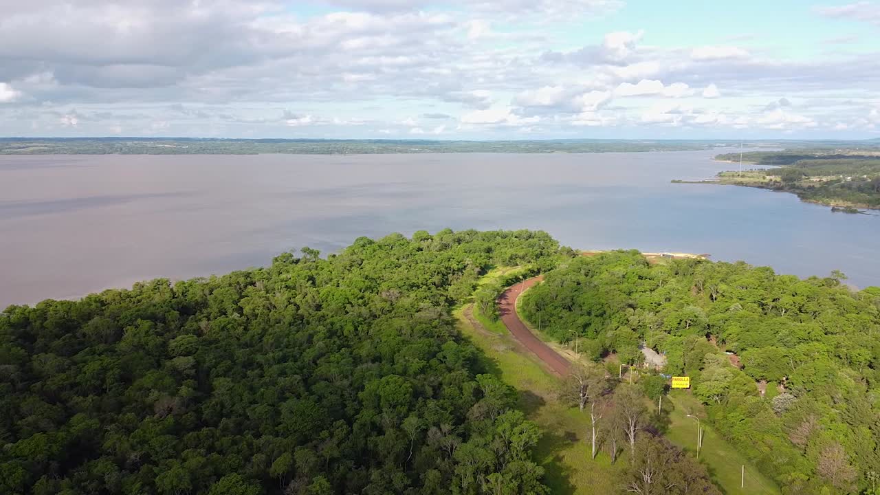 cinematográfica, panorámica, toma aérea de un solo camino de tierra que serpentea a través de un bosque exuberante