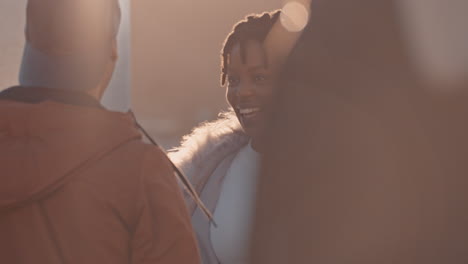 multiracial friends hanging out on rooftop chatting socializing enjoying weekend party gathering dancing to music at sunset