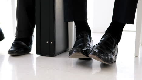 Businessmen-shaking-their-feet-nervously