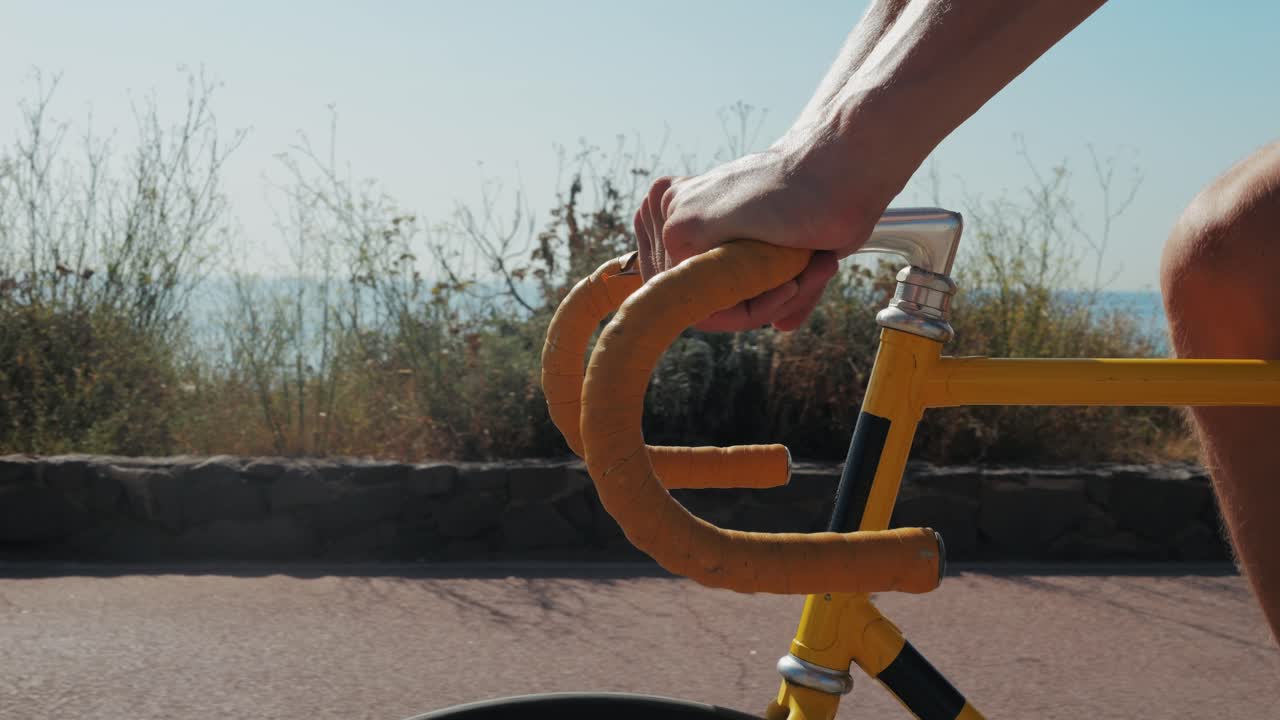 Person Riding a Yellow Bicycle on a Coastal Road
