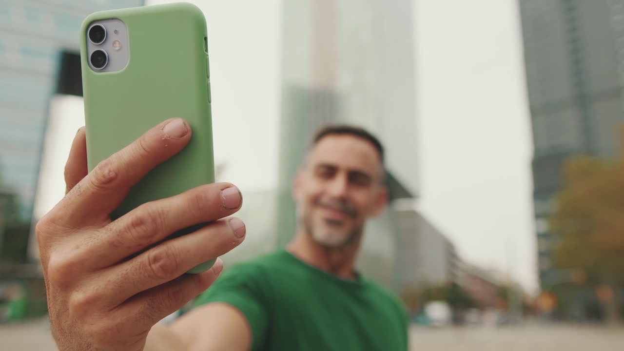 Uomo che si fa un selfie in città