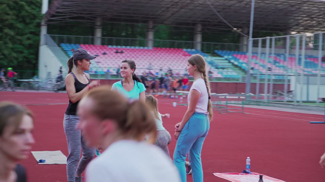 Fit women doing exercise. Group of sporty young girls training at the stadium