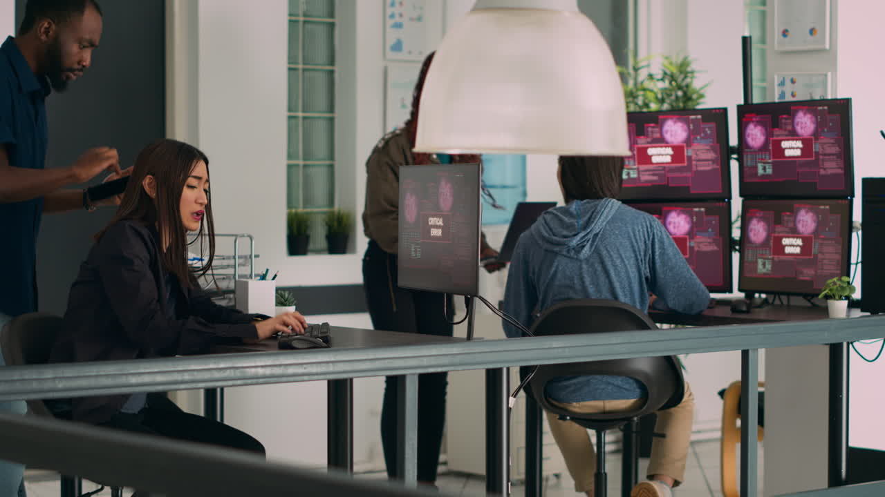Multiethnic team of coders encountering system error message on computer