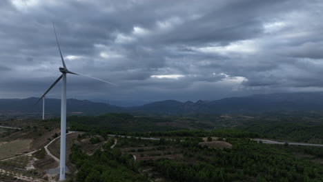 dark moody sky over mountainous terrain with a wind turbine not working