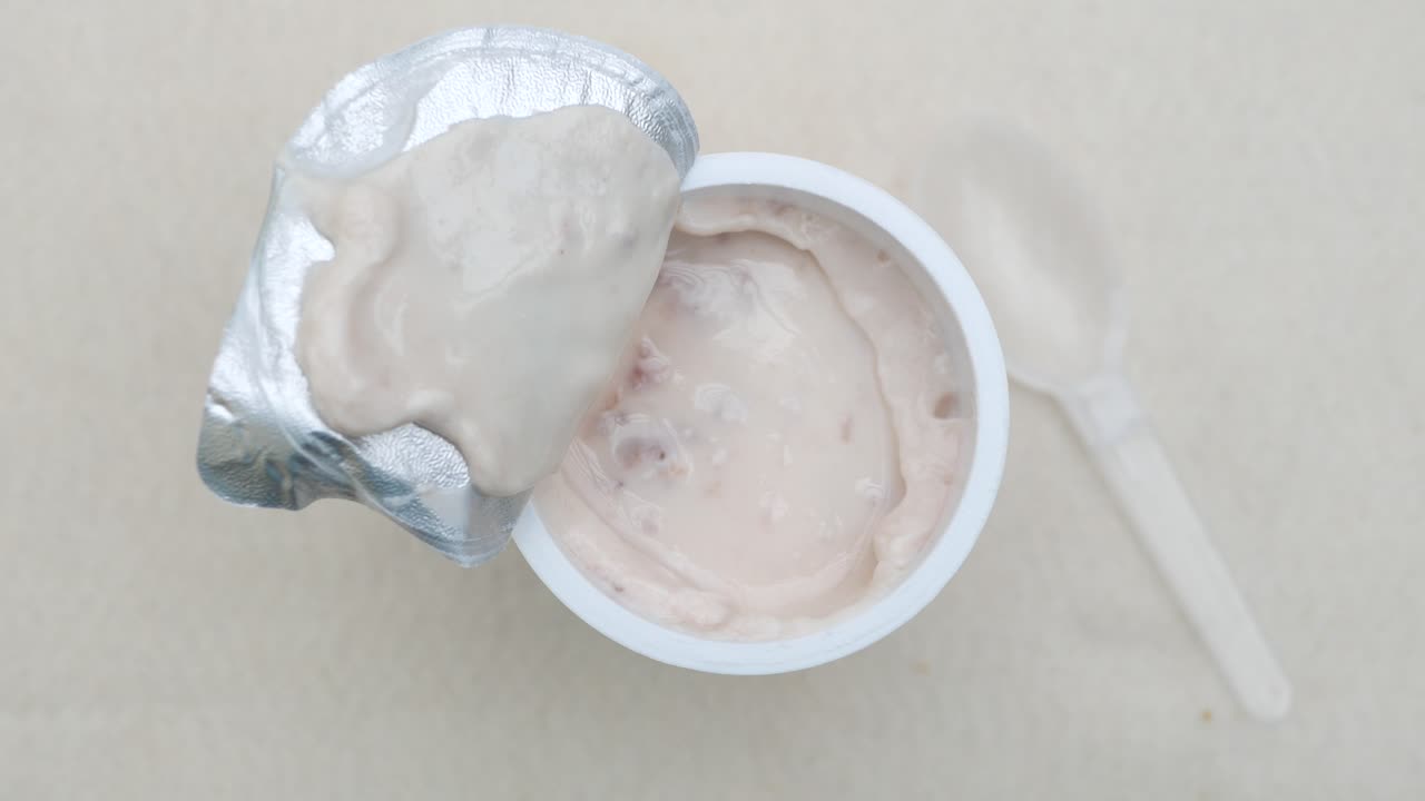 recipiente de yogur abierto con cuchara