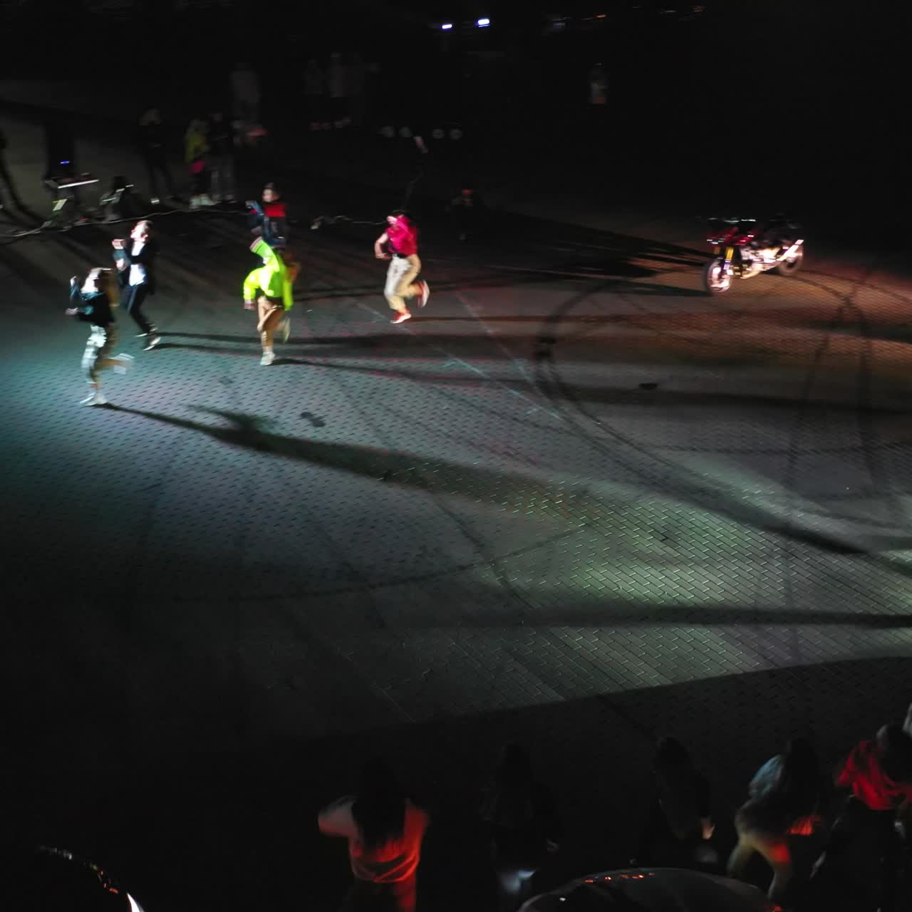 Waktu yang menyenangkan dihabiskan di pesta hip hop. Orang-orang menari di dekat mobil balap pada malam hari. Tampilan dari atas