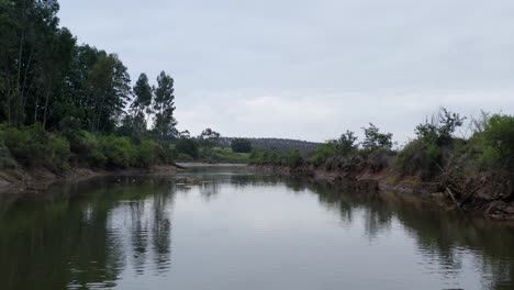 Peaceful-pov-view-as-boat-move-below-bridge-on-tranquil-river