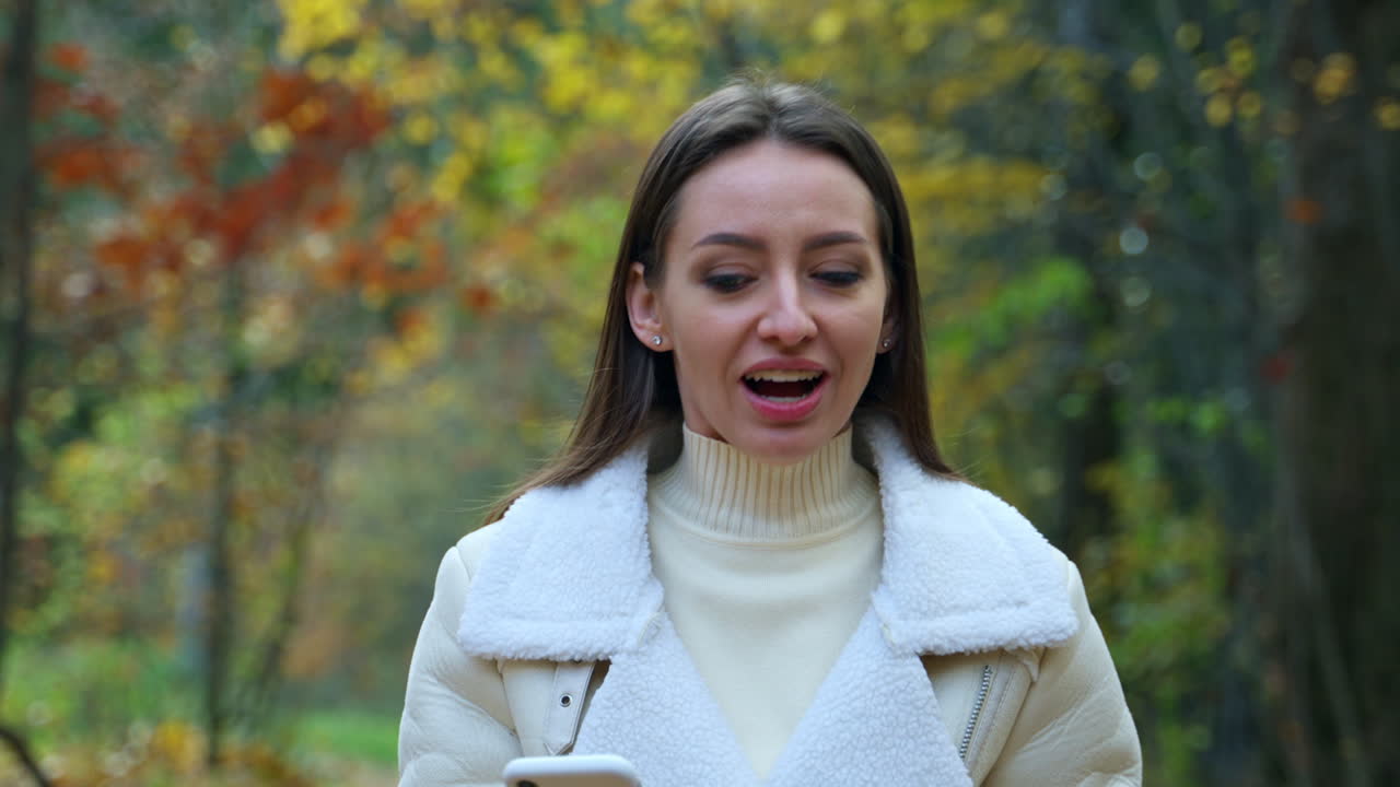 женщина использует телефон в осеннем парке