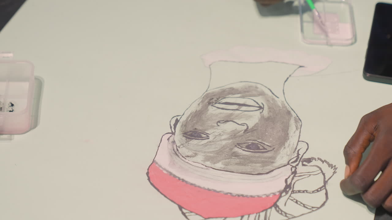 Boceto de retrato de pintura negra sobre papel, primer plano de manos aplicando aguada y acento rosa, mesa con pequeño recipiente y herramientas, pinceladas deliberadas y sombreado tonal, estudio íntimo.