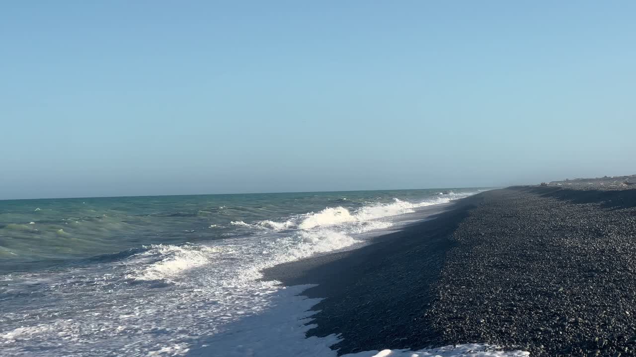 강하고 큰 파도가 해질녘 긴 바위 해변에 충돌