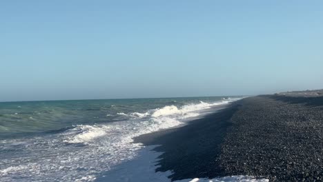 Strong,-large-waves-crashing-ashore-a-long-rocky-beach-at-sunset