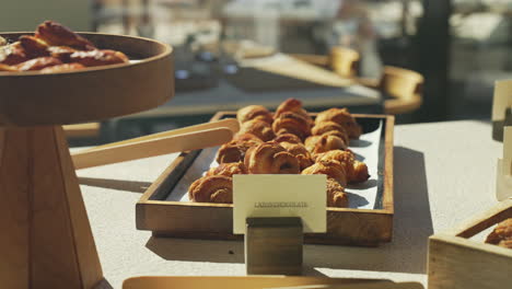 freshly baked croissants presented on a wooden plate during a delightful and sunny morning brunch, creating a mouthwatering and visually appealing breakfast experience