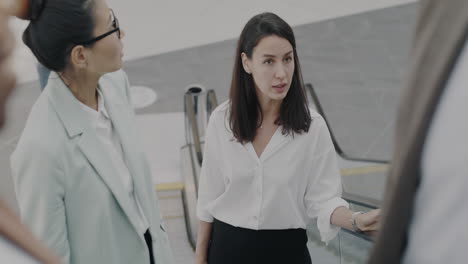 businesswomen discussing on an escalator