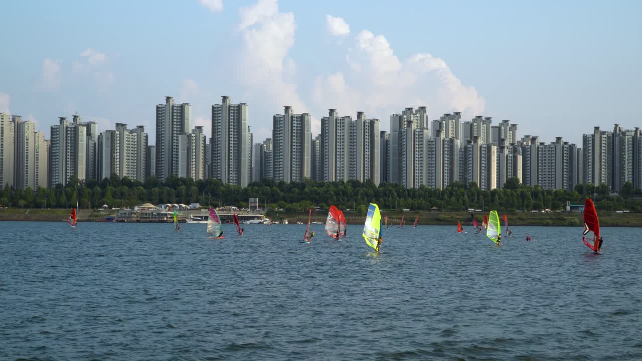 mucha gente haciendo windsurf en el río han durante el día, apartamentos jamsil en el fondo, día nublado