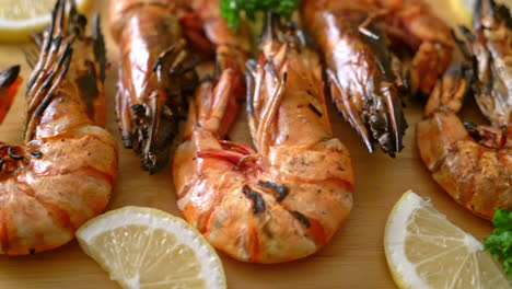 grilled tiger prawns or shrimps with lemon on wood board