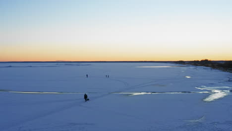 Person-Schleppt-Schlitten-Bei-Sonnenaufgang-Durch-Den-Schnee,-Luftaufnahme