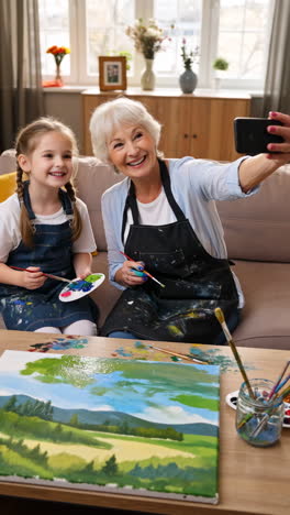 grandmother and granddaughter painting together and taking a selfie