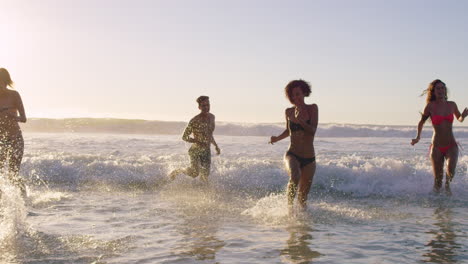 Eine-Vielfältige-Gruppe-Von-Freunden-Schwimmt-Bei-Sonnenuntergang-Im-Meer