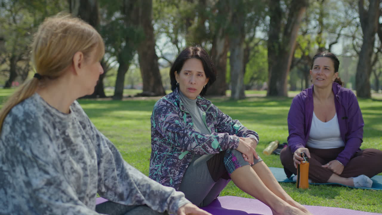 mujeres practicando yoga al aire libre en un parque