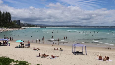 crowded beach scene with people enjoying the ocean