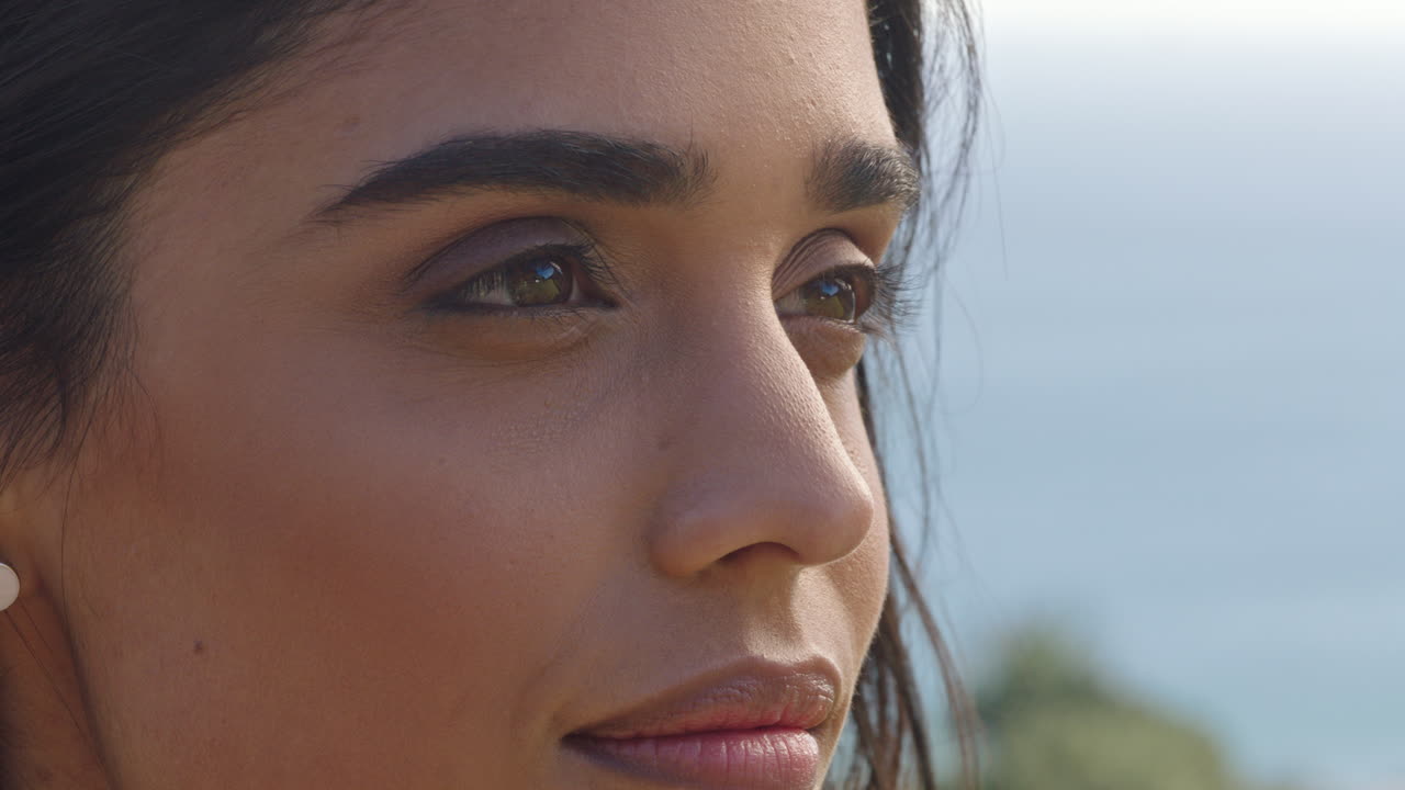 retrato en primer plano de una hermosa mujer india disfrutando de un tranquilo día soleado relajándose en las vacaciones de verano con el viento soplando el cabello