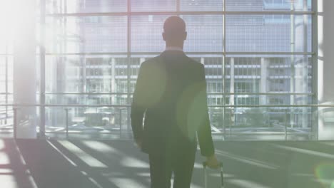 Businessman-standing-with-luggage-in-the-lobby-at-office-4k