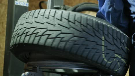 change a tyre, car mechanic is changing a tyre in a garage