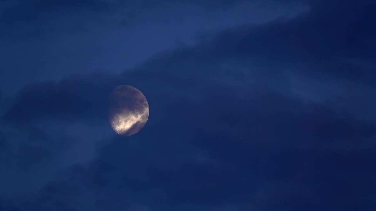 Vista noturna da lua coberta por nuvens escuras em movimento