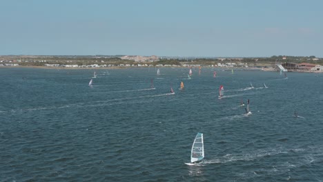 drone - aerial shot of many surfers on a blue, wavy and windy sea on a sunny day with white clouds on a island, zeeland, netherlands, 25p